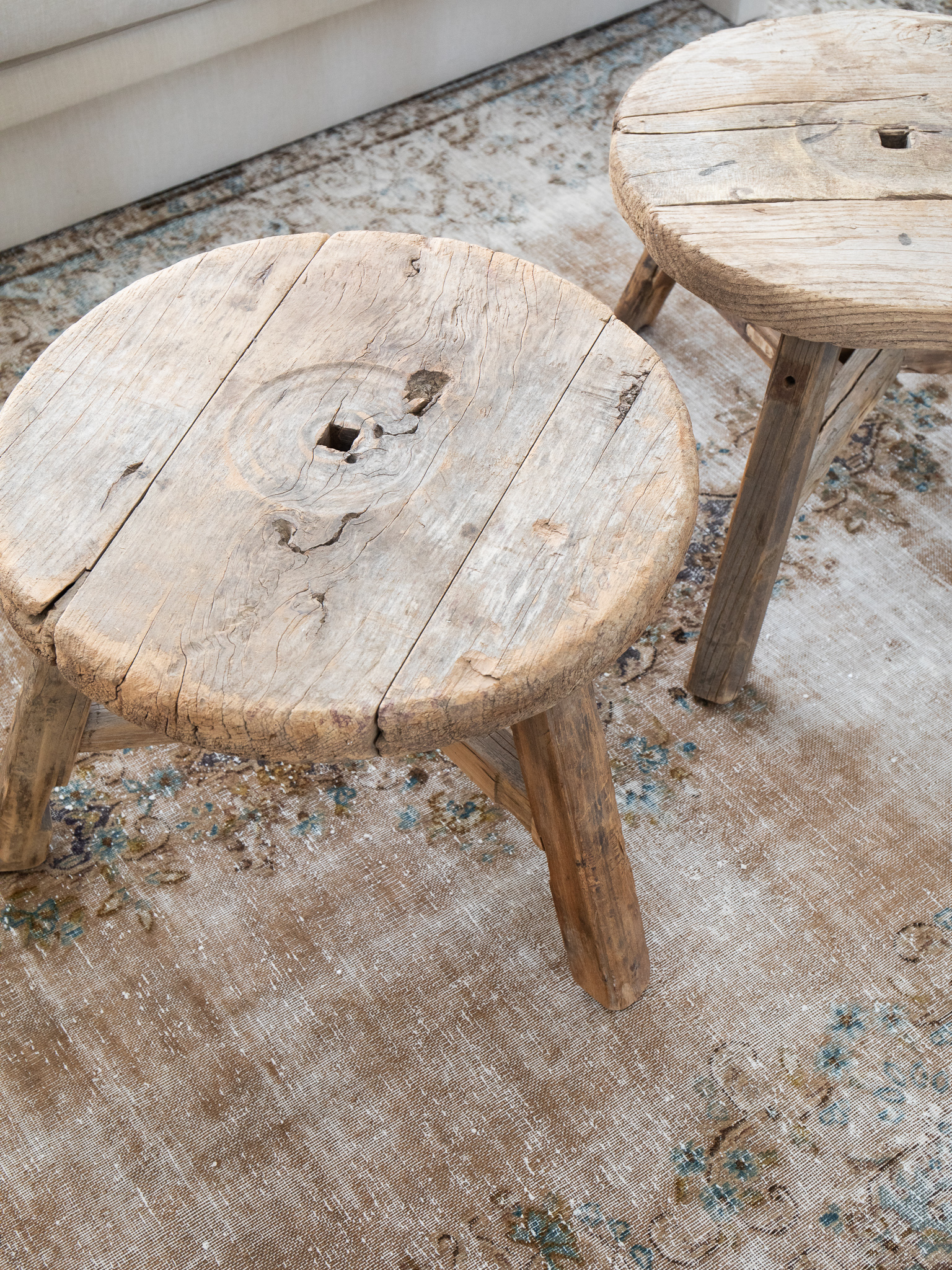 Vintage Tabriz rug with primitive stools